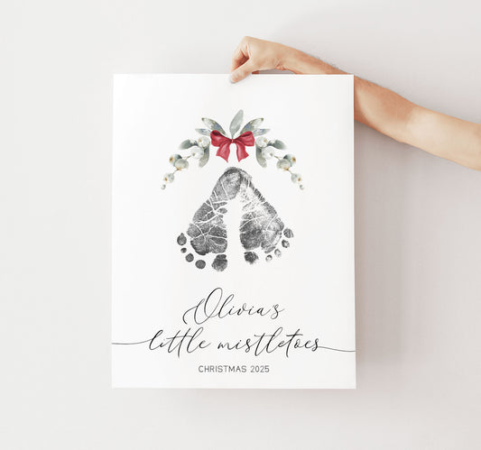 Print with footprints mistletoe, and a bow held by a hand on a white background