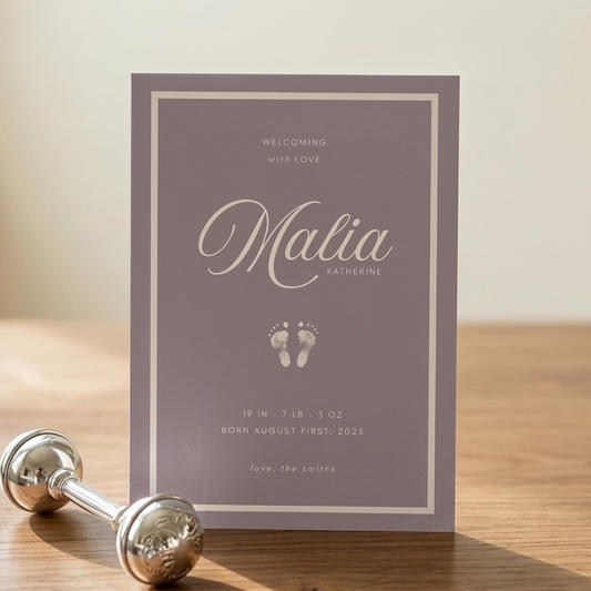 Baby birth announcement card with name 'Malia' and baby footprints on a purple background
