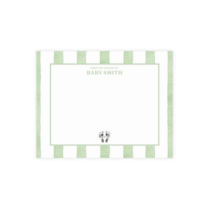 White card with baby footprints, green and white striped border and text.