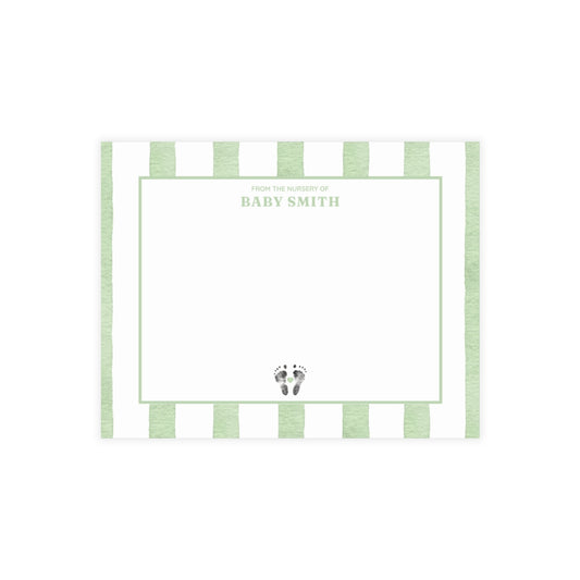White card with baby footprints, green and white striped border and text.