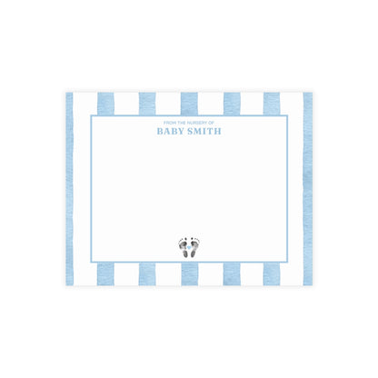 White card with baby footprints, light blue and white striped border and text.