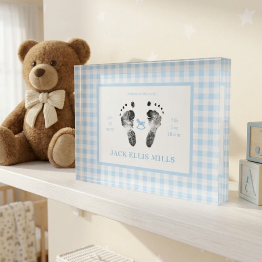 Baby room with teddy bear, baby footprints in a frame, and wooden blocks.